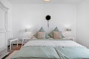 A bedroom with a bed, two nightstands, a chair, and a wall art piece. - Holiday Apartment "Haus Bergruh Fuchsbau" with Mountain View, Private Terrace & Wi-Fi (Todtnauberg)