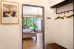 Une chambre à coucher avec un lit, une fenêtre, un lustre et un porte-manteau.