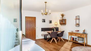 Un dormitorio con cama, escritorio, silla, aparador de madera y candelabro.