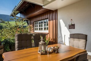 Una mesa de madera con sillas, un farol y objetos decorativos.