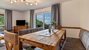 A modern dining area with a wooden table, chairs, and a bench. - Holiday Apartment "Fuchsmichelhof 2" (Seebach)