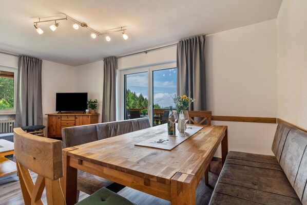 A modern dining area with a wooden table, chairs, and a bench.