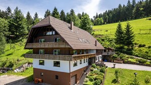 A two-story chalet with a balcony, a garage, and a driveway. - Holiday Apartment "Fuchsmichelhof 2" (Seebach)