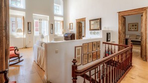 Una habitación amplia con una escalera de madera, un sofá y una mesa de comedor.