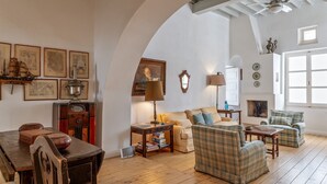 Amplia sala de estar con un techo abovedado, chimenea y un ventanal grande.