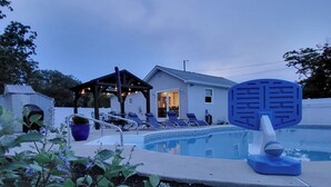 A swimming pool with lounge chairs, a covered patio, and a house in the background. - The Perfect Escape with Gorgeous Heated In-Ground Pool (Lower Township)
