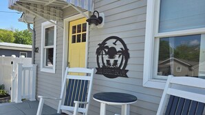 A house with a yellow door, a rocking chair, and a small table. - The Perfect Escape with Gorgeous Heated In-Ground Pool (Lower Township)