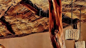 Un interior rústico con un banco de madera y un tronco de árbol usado como soporte.