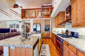 Enjoy cooking and relaxing in this well-appointed kitchen with a central island, modern appliances, and a cozy seating area.
