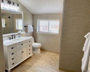 Bathtub, hair dryer, towels, shampoo