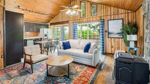 Un intérieur de chalet chaleureux comprenant un coin repas, un canapé, une cheminée et une cuisine.