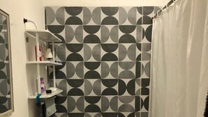 Et badeværelse med toilet, håndvask og hylder.