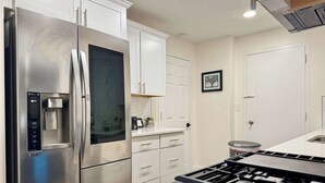 A modern kitchen with stainless steel appliances, white cabinetry, and a gas stove. - Historic Condo in Atlanta with Skyline View (Atlanta)