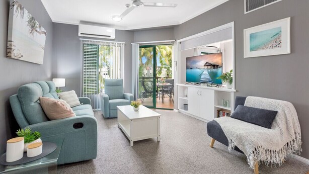 Una sala moderna con sofá, sillón y mesa de centro.