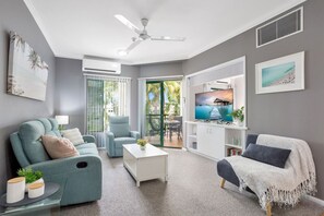 Una sala moderna con sofá, sillón y mesa de centro.