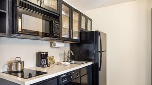 A modern kitchen with a black refrigerator, a coffee maker, and a stainless steel pot on the counter. - Modern Oasis in Plano, Texas! 2 Spacious Units, Full Kitchen, Pets Allowed! (Plano)
