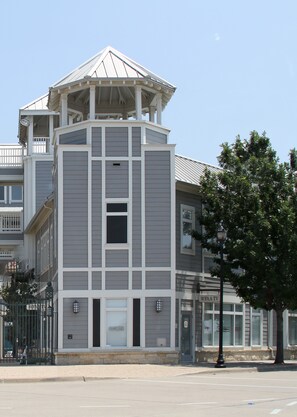 A multi-story building with a central tower and a covered balcony. - Modern Oasis in Plano, Texas! 2 Spacious Units, Full Kitchen, Pets Allowed! (Plano)