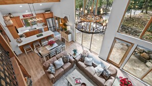A spacious living area with a large window, a dining table, and a sofa.