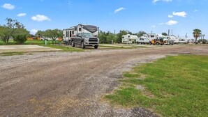A gravel road with RVs parked on the side. - Mathis Motel (Mathis)
