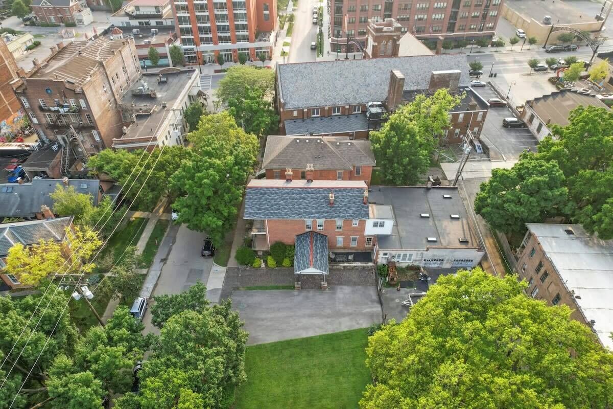 An aerial view of a building with a central courtyard, surrounded by trees and adjacent buildings.