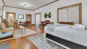 Un dormitorio amplio con una cama grande, un escritorio y una silla, además de una sala de estar con un sofá y una mesita de centro.