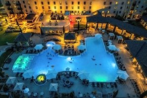 Une vue aérienne d’un hôtel doté d’une grande piscine, d’espaces de détente en plein air et de plusieurs bâtiments.