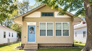 A single-story house with a blue door, numbered 2546, and a small porch with steps leading up to it. - Charming Retreat | Walkable • Private Fenced Yard (Indianapolis)