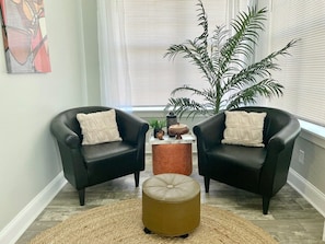 Relax in this inviting living space with comfortable seating and lush greenery.