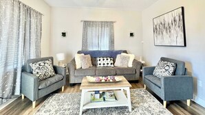 A modern living room with two grey sofas, a coffee table, and a ceiling fan. - Newly Remodeled 2 Bedroom Home in Shelbyville! (Shelbyville)
