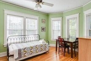 A bedroom with a bed, a desk, and a chair.