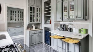 Una cocina moderna con gabinetes grises, una encimera blanca y un horno empotrado.