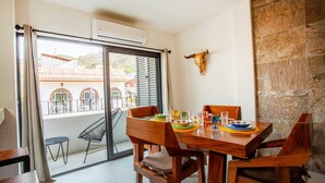 A dining area with a table set for four, a balcony with a view, and a bull's head decoration on the wall. - Beautiful Casa Madero 470 (Puerto Vallarta)