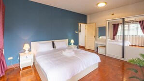 A bedroom with a bed, nightstands, a mirror, and a wardrobe. - Spacious 3BR Private House Near Old City Near Night Bazaar (Muang Chiang Mai)