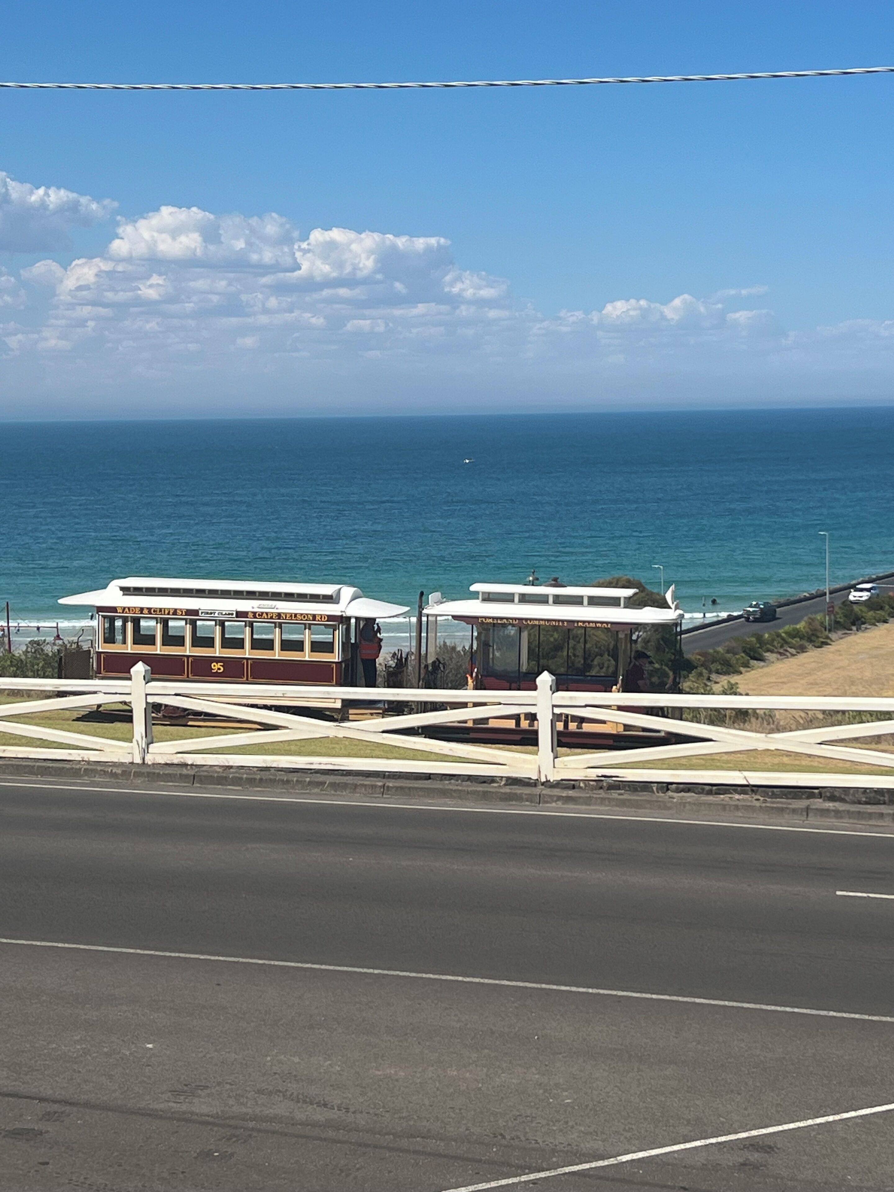 A coastal road with a bus stop and a view of the ocean.