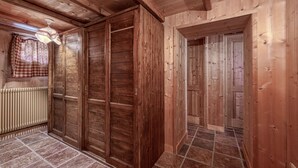 Un interior de madera con un radiador, una cortina a cuadros y un ventilador de techo.