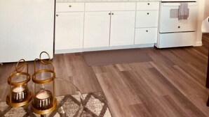 A modern kitchen with white cabinets, a microwave, stove, and a sink. - North Star Place Apt 12 (Fairbanks)