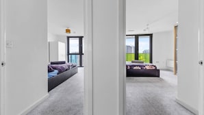 Una camera da letto moderna con un ampio letto, vista sulla città e un balcone.
