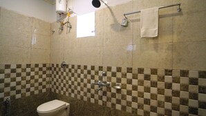 A bathroom with a toilet, a shower, and a towel rack. - Royal Sea View (Kanthi)