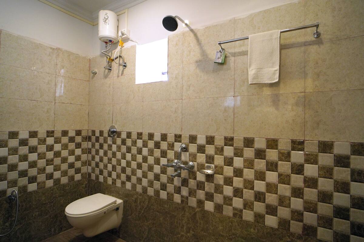 Un baño con inodoro, ducha y toallero.