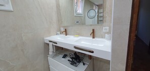 Une salle de bain avec deux lavabos, un miroir et un porte-serviettes.