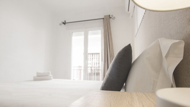 Une chambre d’hôtel avec un lit, une table de chevet et une vue sur un balcon.