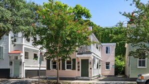 A row of two-story houses with a tree in the foreground. - Beautiful Penthouse Condo Just Steps to King (Charleston)