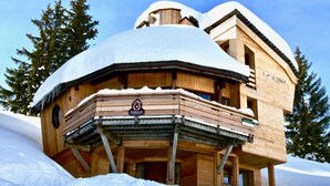 Un chalet en bois, dont le toit est recouvert de neige, avec un balcon et une enseigne sur laquelle on peut lire « Le Tequila ».