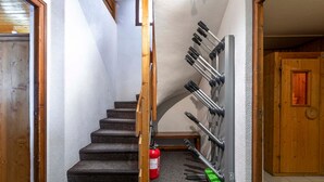 Un escalier avec un extincteur et un porte-outils fixé au mur.