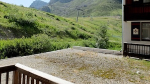 Paesaggio montano con una seggiovia e un edificio con un balcone.