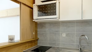 Una cucina con forno a microonde integrato, lavello e lavastoviglie.