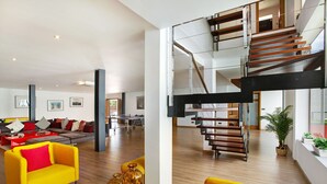 A spacious living area with a modern staircase, a sofa, and a coffee table. - Villa "Tauro 31" with Sea Views, Private Pool, and Wi-Fi (Mogán)