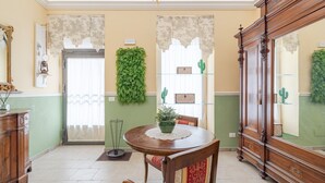 Un coin repas comprenant une table en bois, des chaises, un buffet et un miroir.