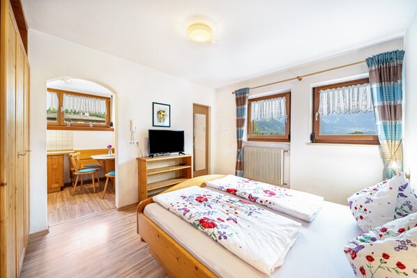 A bedroom with two beds, a desk, a chair, and a TV. - Holiday Apartment 'Erlengut Meran' with Mountain View, Shared Pool and Wi-Fi (Lana)