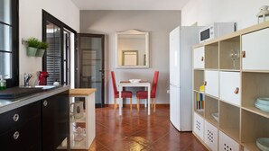 A modern kitchen with a dining area, a white refrigerator, and a built-in bookshelf. - Vacation Home 'Casa Jess' with Private Terrace, Private Garden and Wi-Fi (Tías)